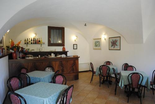 a restaurant with tables and chairs and a counter at Hotel Tiziana Garnì in Gargnano