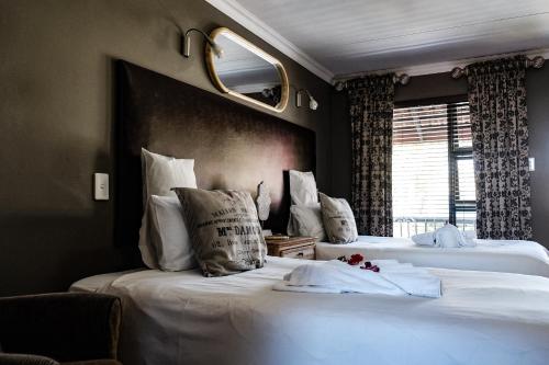 two beds in a hotel room with white pillows at Big 5 Guest House Witbank in Witbank