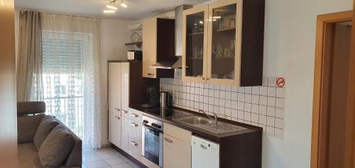 a small kitchen with a sink and a window at Outletcity Ferienwohnung Wohnung 2 in Metzingen