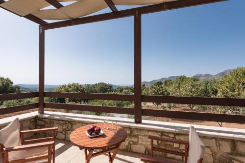 a table and chairs on a balcony with a view at Koules Estate, with Private Pools & BBQ - embracing Nature, By ThinkVilla in Argoulión
