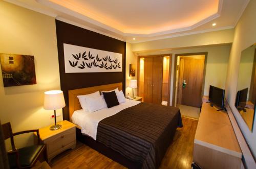 a hotel room with a large bed and a large window at Lydia Hotel in Rhodes Town
