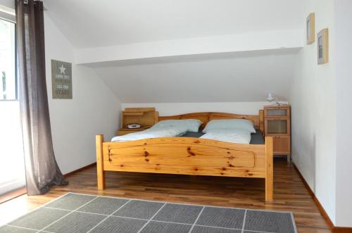 ein Schlafzimmer mit einem Holzbett mit zwei Kissen in der Unterkunft Ferienwohnung Nico in Mühlbach am Hochkönig