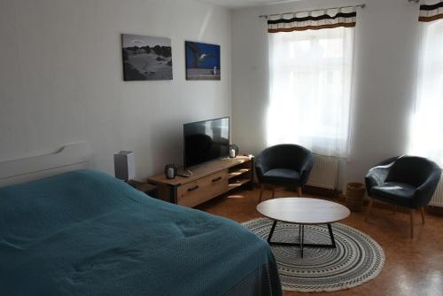 a bedroom with a bed and a tv and chairs at Marktquartier in Reichenbach