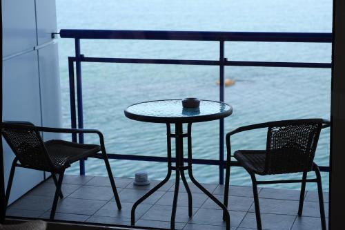 a table and chairs on a balcony with a view of the water at Maristella Marine Residence in Odesa