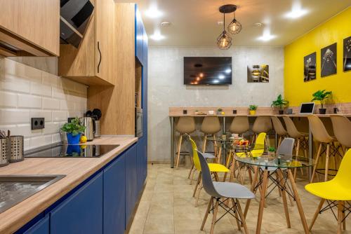 een keuken en eetkamer met gele stoelen en een tafel bij HiLoft Hostel in Sotsji