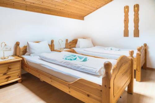 two twin beds in a room with wooden ceilings at Gasthof Pesbichl in Goldegg