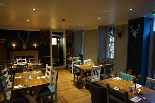 a restaurant with wooden tables and chairs and a fireplace at The Barge Inn in Bradford on Avon