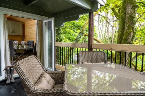 a screened in porch with a glass table and chairs at Kintala Resort & Spa in Dungiven