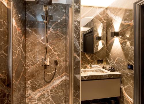 een badkamer met een douche, een wastafel en een spiegel bij Cavallaro Hotel in Haarlem