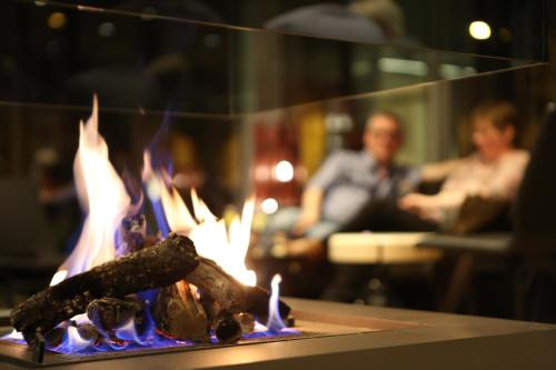 a fire in a table with people in the background at Ariane Hotel in Ieper