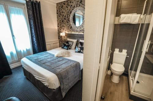 a hotel room with a bed and a toilet at Hotel De La TA in Rennes