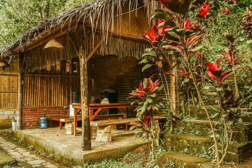 uma cabana com uma mesa e um banco à sua frente em Buda's Homestay Lemukih em Pabean Buleleng
