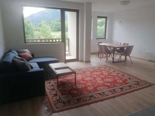 ein Wohnzimmer mit Sofa und Tisch in der Unterkunft Комплекс Падалото "ЕТНО" in Smoljan