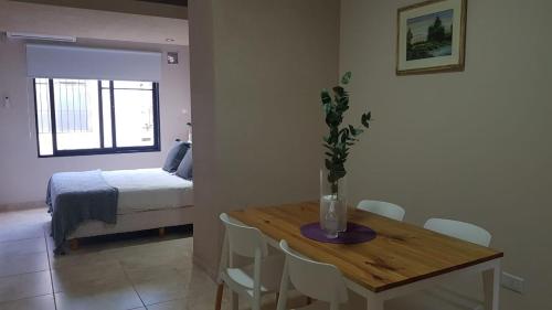 a room with a table and a bedroom with a bed at Departamentos Rivadavia in Mendoza