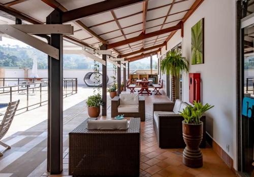 a patio with chairs and tables on a roof at Bliss Hotel Vale do Café in Vassouras