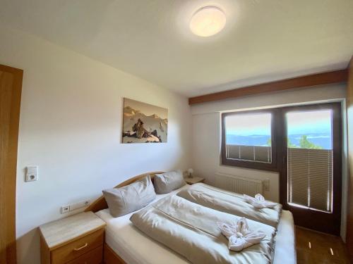 a bedroom with a bed and a large window at Canisiusbrünnl Self- Check in in Innsbruck