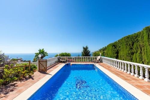 a swimming pool with a balcony and the ocean in the background at Villa Magica Andalucian charm in Benalmádena