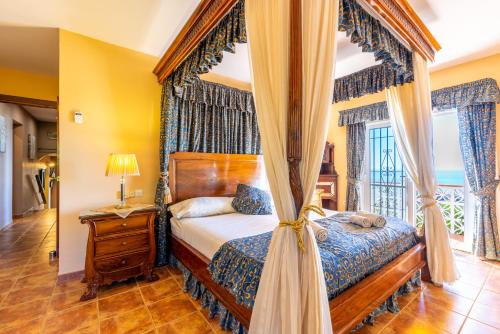 a bedroom with a canopy bed and a window at Villa Magica Andalucian charm in Benalmádena