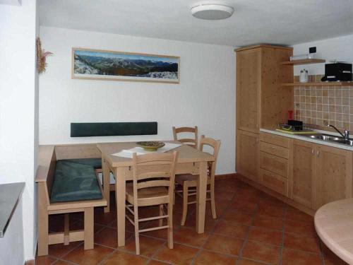 a kitchen with a table and chairs in a kitchen at Casa Vacanze IL BEARČ in Feltrone