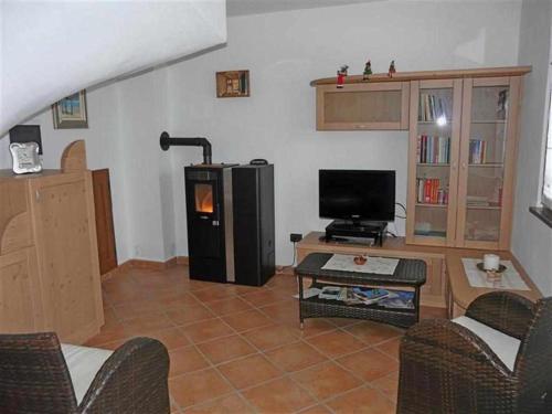 sala de estar con TV y mesa en Casa Vacanze IL BEARČ, en Feltrone