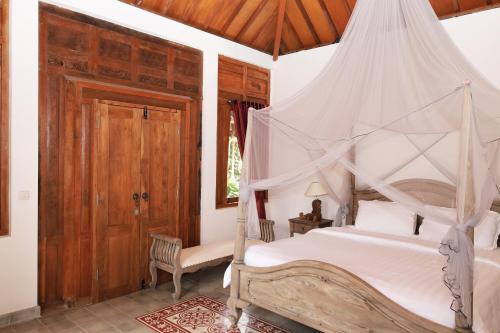 a bedroom with a bed with a mosquito net at Bhumi Kasuryan Borobudur in Borobudur
