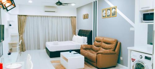 a living room with a couch and a chair in a room at Signature Apartment at Mercu Summer Suites KLCC in Kuala Lumpur