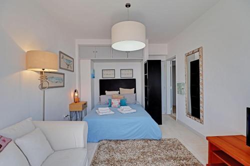 a living room with a bed and a couch at Faro Airport Flats by Homing in Faro