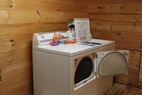 a washer and dryer in a room with wooden walls at Country Road Cabins in Hico