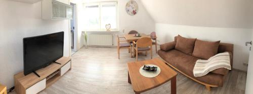 a living room with a couch and a tv and a table at Ferienwohnung Max in Rethwisch