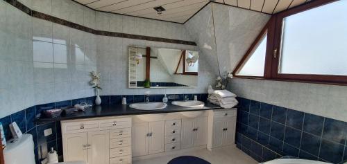 a bathroom with two sinks and a mirror at Maison de vacances proche Strasbourg et Europa park in Sand