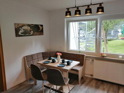 una sala da pranzo con tavolo, sedie e finestra di Apartment am Felsen Züschen a Winterberg