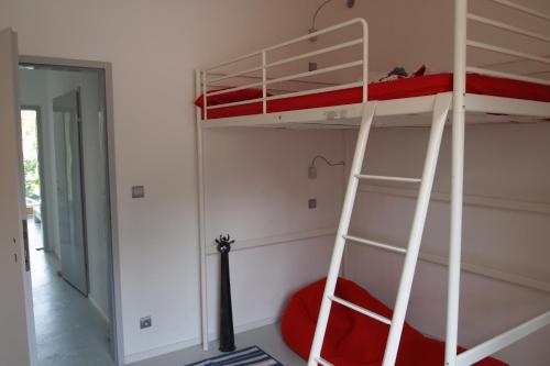 a bedroom with two bunk beds and a ladder at Apartamenty Poli House in Krynica Morska