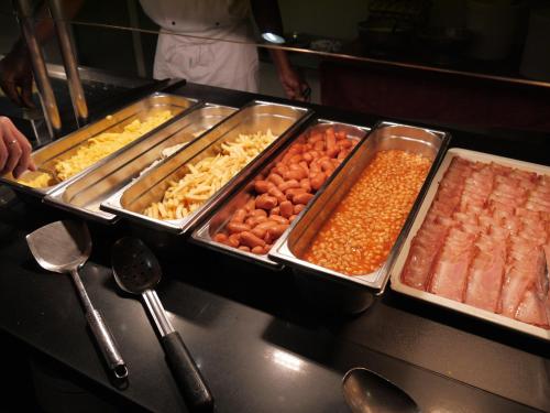 a buffet line with trays of different types of food at Hotel la Palmera & Spa in Lloret de Mar
