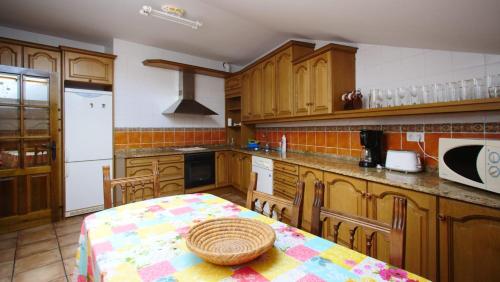 a kitchen with wooden cabinets and a table with a basket on it at Casa Rural Plaza Vieja Saldaña in Saldaña