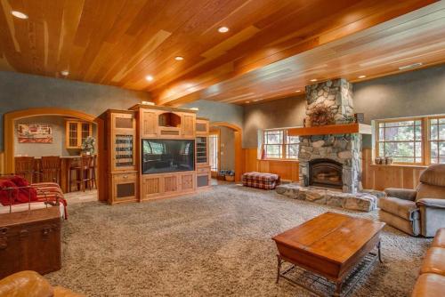 a living room with a fireplace and a tv at Snowgrass Lodge - River, Mountain Views & Hot tub in Leavenworth