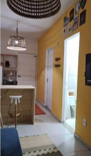 a room with a kitchen with a counter and a table at Formosinha in Baía Formosa