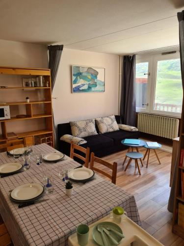 un salon avec une table et un canapé dans l'établissement La Mongie Yes !, à Bagnères-de-Bigorre