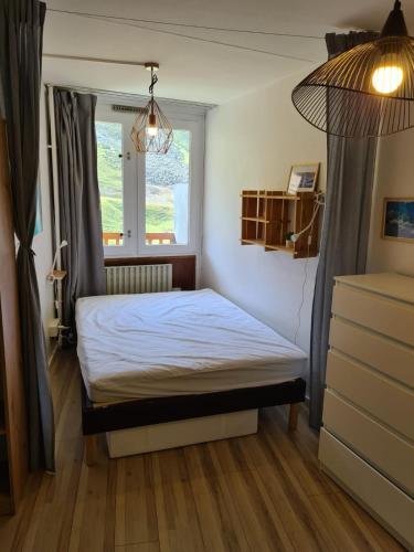 une petite chambre avec un lit et une fenêtre dans l'établissement La Mongie Yes !, à Bagnères-de-Bigorre