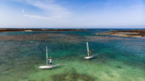 two people are standing on paddle boards in the water at Siempre Feliz La Casita Escanfraga in Villaverde