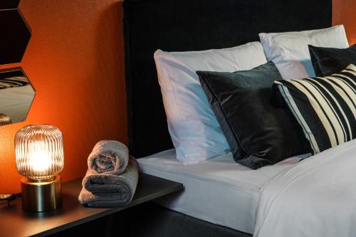 a bed with pillows and a lamp on a table at Timėjas in Ringaudai