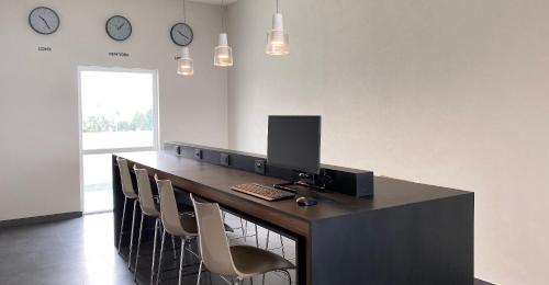 a office with a desk with chairs and clocks on the wall at Hotel MX mas cuautitlan Izcalli, Trademark by Wyndham in Cárdenas