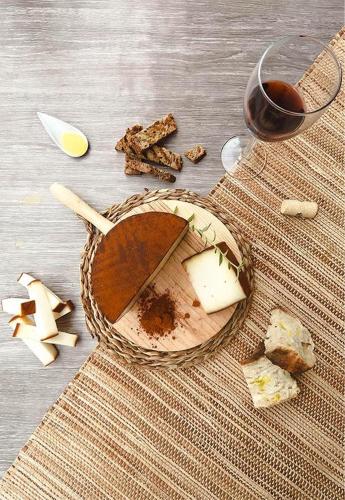 a basket of cheese and a glass of wine on a table at Siempre Feliz La Casita Escanfraga in Villaverde