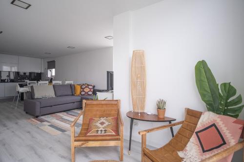 Una sala de estar con dos sillas y un sofá. en Foz - West Shore Retreat, en Caldas da Rainha