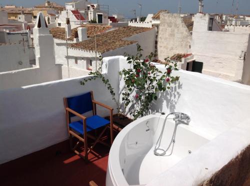 La salle de bains est pourvue d'une baignoire et d'une chaise sur le toit. dans l'établissement RifugioAzul & RifugioAzul Boutique, à Ciutadella