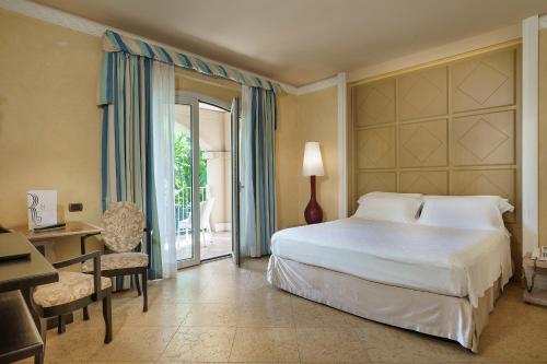 a hotel room with a bed and a desk and a desk at Romano Palace Luxury Hotel in Catania