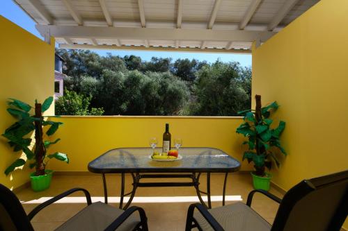 a table with a bottle of wine on a balcony at Pension Elena in Ágios Nikólaos