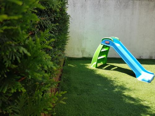 a blue and green plastic slide in a yard at Porto In Sight, 4 Kids in Vila Nova de Gaia