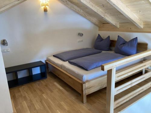 a bed with blue pillows in a room at Kurzenwirt - Ferienwohnungen in Kiefersfelden