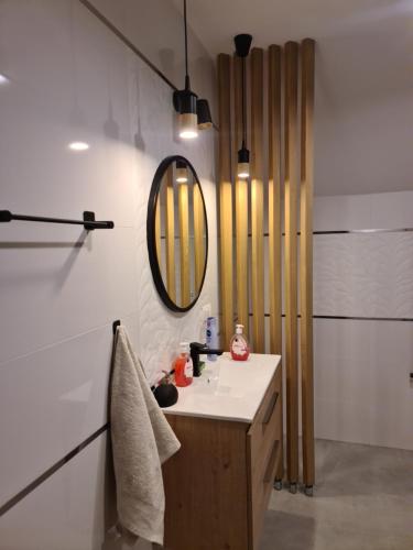 a bathroom with a sink and a mirror at Apartament Limanowa Rynek in Limanowa