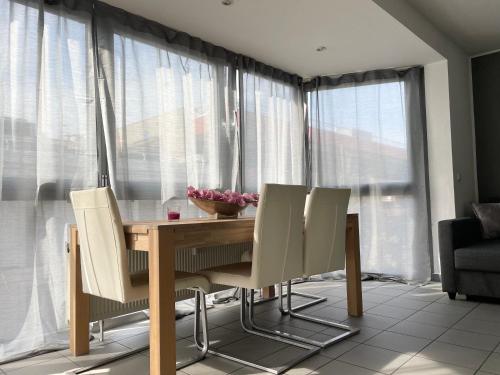 a dining room table with white chairs in front of a window at Innenstadt Neumarkt-Schildergasse stylische Wohnung in Cologne